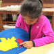 Montessori math materials arranged neatly on a shelf, including decimal system blocks and golden beads.