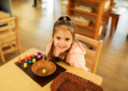 Children using Montessori knobbed cylinders to refine their sense of size and dimension.