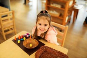 Children using Montessori knobbed cylinders to refine their sense of size and dimension.