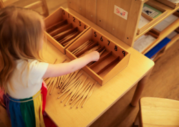 Children using Montessori knobbed cylinders to refine their sense of size and dimension.