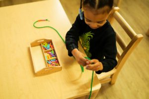 Montessori classroom where students are focused on self-paced learning with sensory materials.