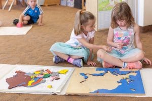 Students participating in grace and courtesy lessons, learning to work cooperatively in a Montessori environment.