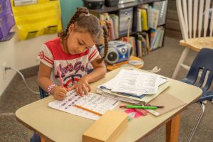 Montessori classroom where students are focused on self-paced learning with sensory materials.