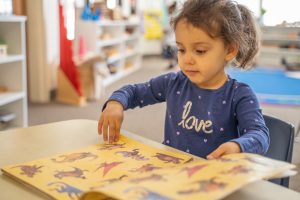 A child using Montessori binomial cubes to learn about algebraic concepts through hands-on exploration.