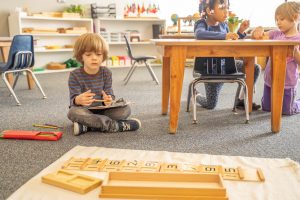 Montessori art corner where children are painting using natural brushes and materials.