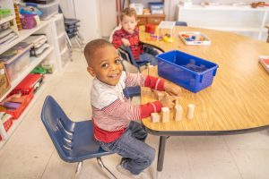 Montessori classroom where students are focused on self-paced learning with sensory materials.