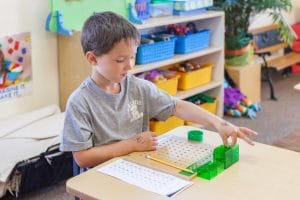 Children engaged in practical life activities, cleaning and organizing the Montessori classroom.