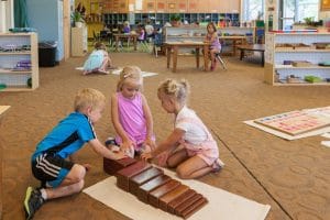 Montessori art corner where children are painting using natural brushes and materials.