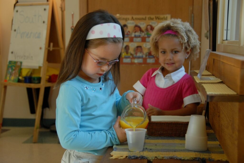 A child working independently with Montessori pink tower cubes to develop spatial awareness.