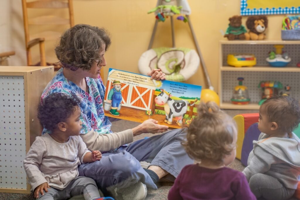 Montessori teacher observing a student completing a pouring activity with precision.