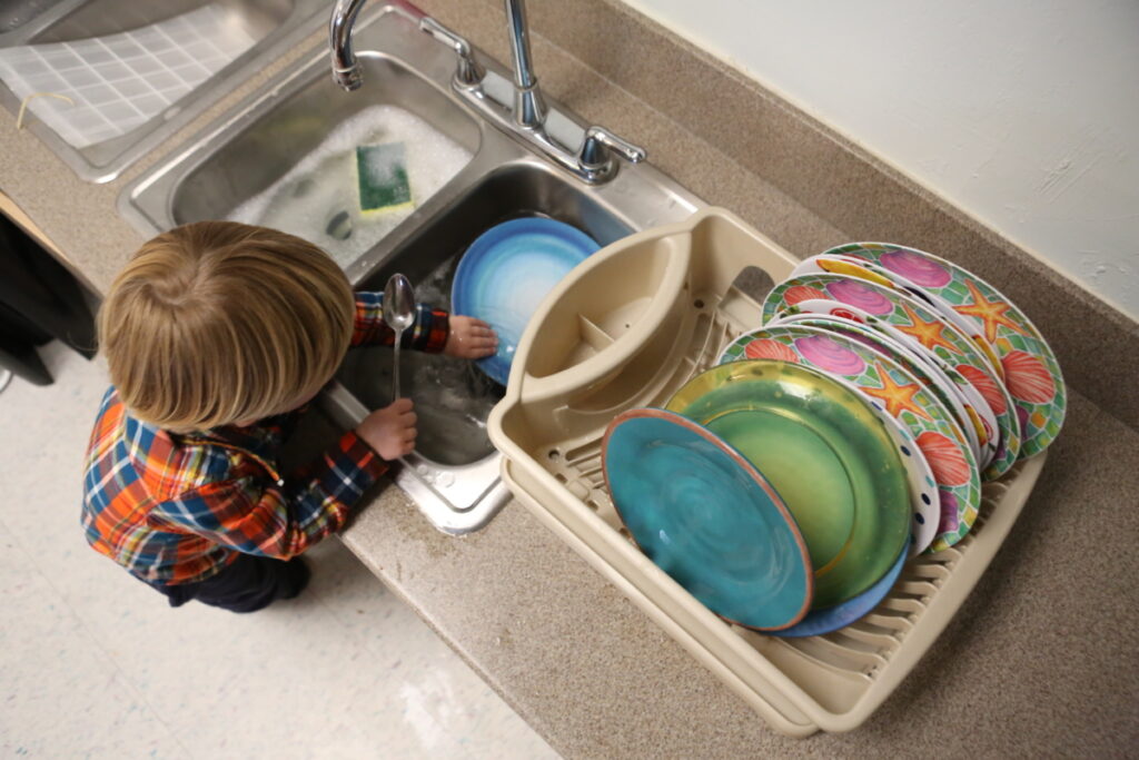 Montessori classroom shelves displaying sensory materials such as color tablets and fabric swatches.