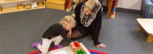 A student using Montessori number rods to understand counting and measurement.